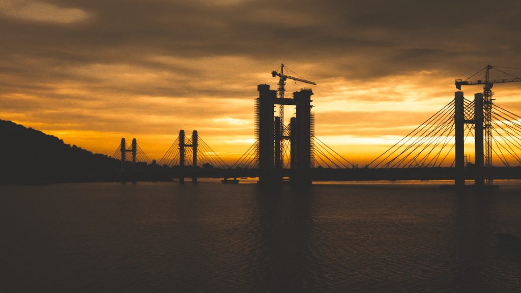 a large body of water with a bridge in the background